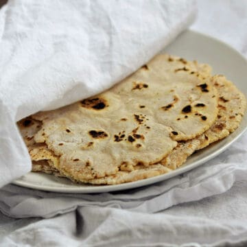 A-stack-of-cassava-flour-tortillas-recipe-on-a-plate-wrapped-with-white-towel.