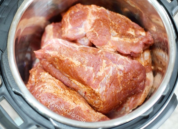 Seasoned pork pieces stacked  in an Instant pot liner.