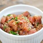raw ahi poke sprinkled with sesame seeds in a white bowl