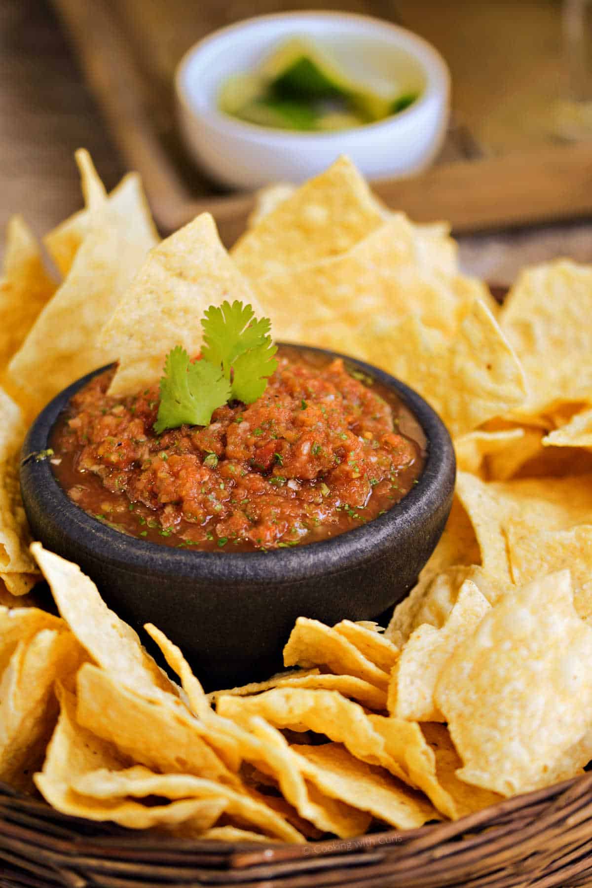 Restaurant style blender salsa surrounded by tortilla chips.