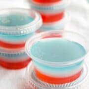 Red white and blue jello shots in small plastic containers.