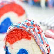 Red white and blue swirled cake with patriotic sprinkles on top.