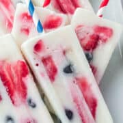Creamy white popsicles filled with red and blue berries.