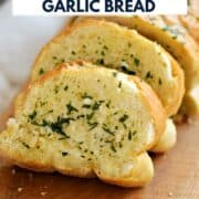 Garlic bread slices on a wood board with title graphic across the top.