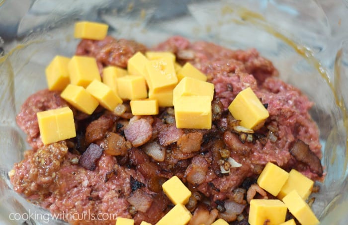Ground beef, bacon, and cheese chunks in a large glass bowl.
