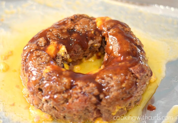 A ring shaped Instant Pot Bacon Cheeseburger covered with barbecue sauce on a baking sheet.