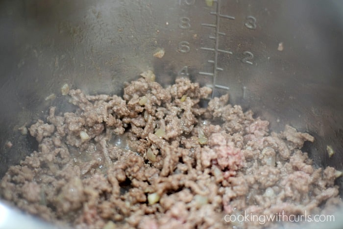Browned ground beef cooking in an Instant Pot.