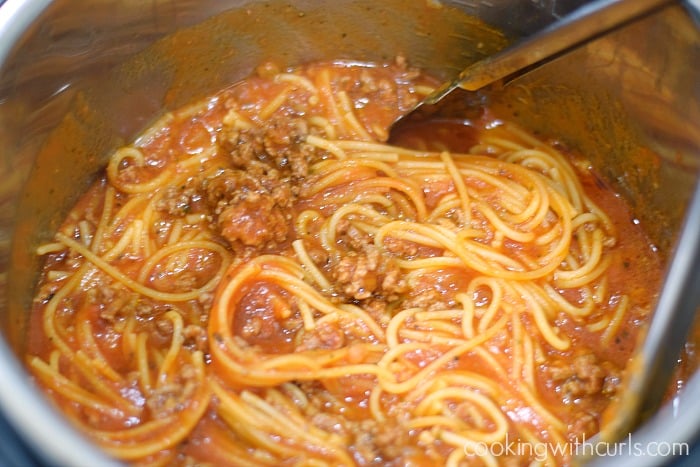 Cooked spaghetti and meat in sauce stirred together in an Instant Pot.