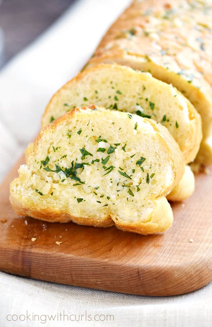 The Best Garlic Bread sliced on a wood board.