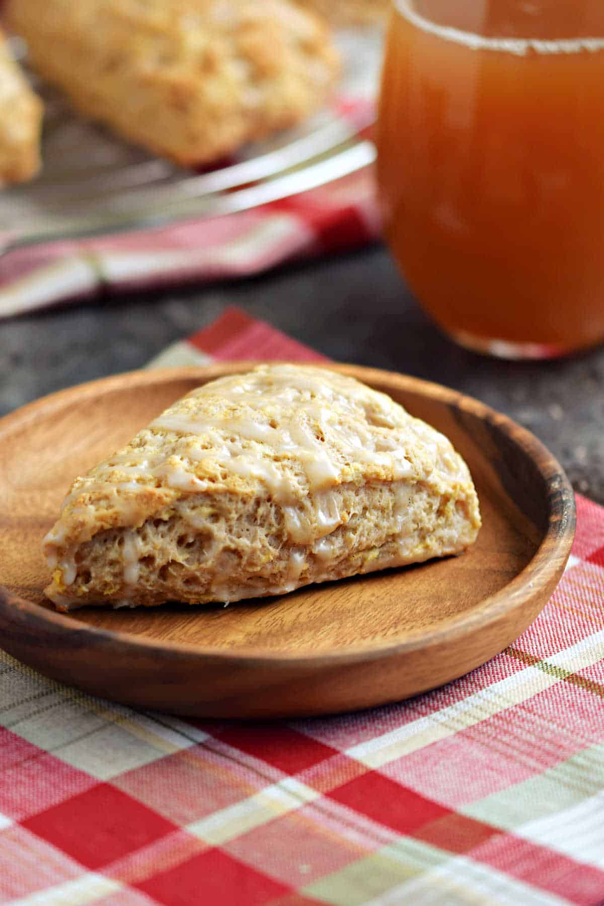 One triangular scone on a wood plate.