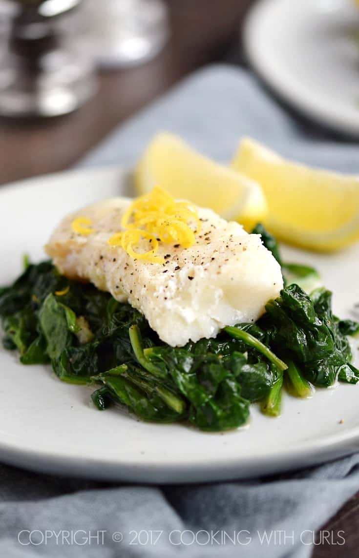 Cod with lemon zest on a bed of sautéed spinach.