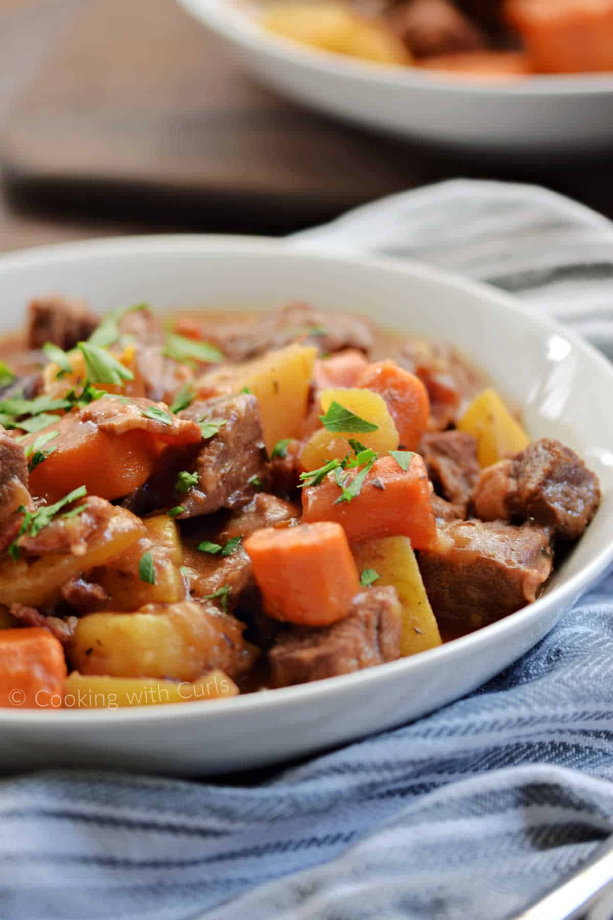 A bowl of Guinness beef stew with carrots and potatoes.