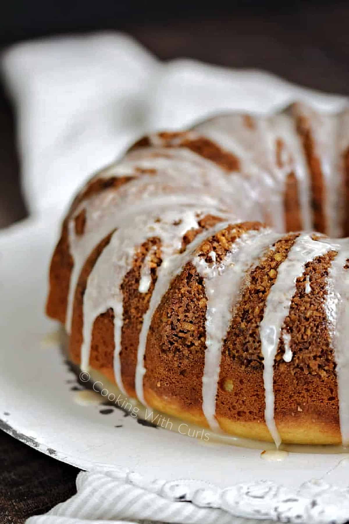 Bundt-shaped Cinnamon-Pecan Coffee Cake topped with glaze on a serving platter. 