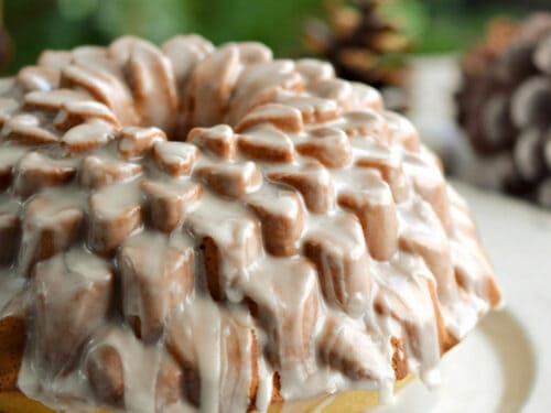 https://cookingwithcurls.com/wp-content/uploads/2017/11/A-glazed-Spiked-Eggnog-Bundt-Cake-recipe-on-a-serving-platter-sitting-in-front-of-a-Christmas-tree.-cookingwithcurls.com_-500x375.jpg