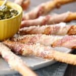 Bacon-Wrapped Breadsticks Appetizer sprinkled with spicy Parmesan and served with Basil Pesto is a perfectly simple appetizer for your next party! COPYRIGHT © 2017 COOKING WITH CURLS