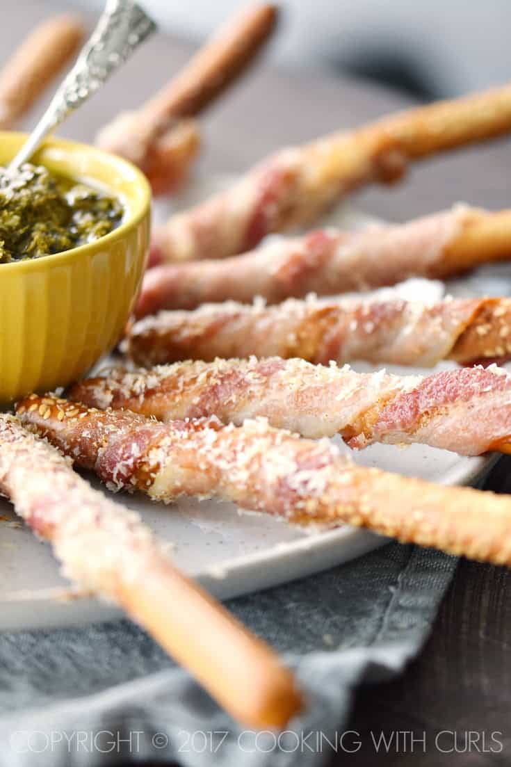 Bacon-Wrapped Breadsticks Appetizer sprinkled with spicy Parmesan and served with Basil Pesto is a perfectly simple appetizer for your next party! COPYRIGHT © 2017 COOKING WITH CURLS