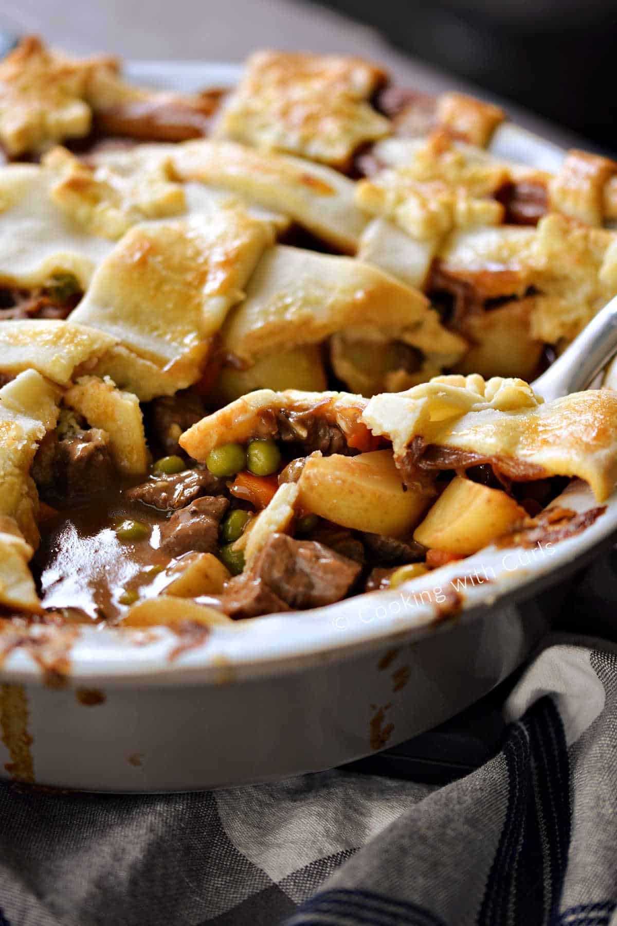 A whole beef pot pie with a slice cut out. 