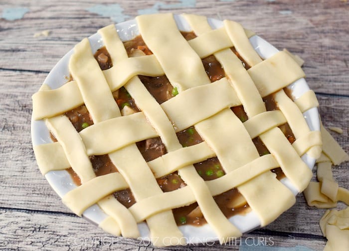 Pie crust strips in a lattice pattern across the pie dish with beef filling.