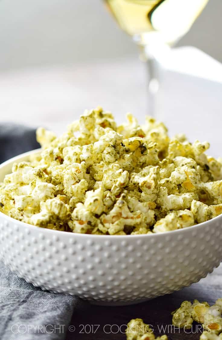 A white bowl filled with salsa verde popcorn.