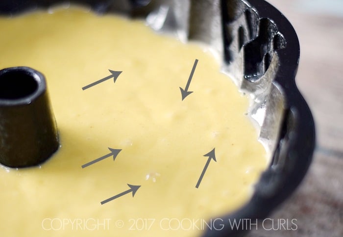 Arrows pointing to bubbles in the cake batter.