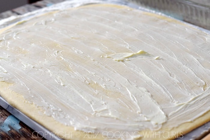 Softened butter spread out over the dough rectangle.