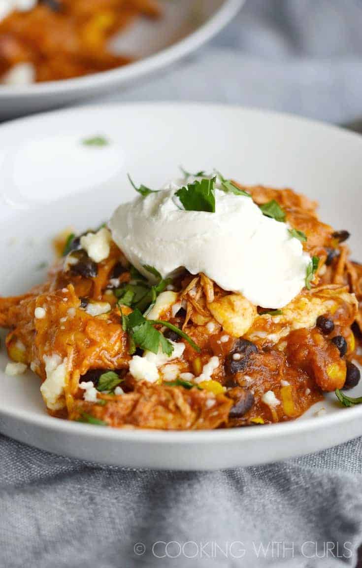 Instant Pot Mexican Casserole in a white bowl topped with sour cream and chopped cilantro.
