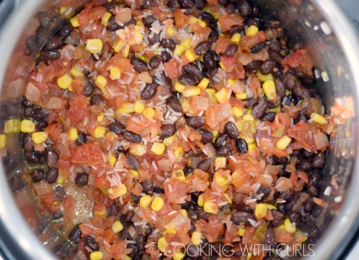 Black beans, corn, salsa and rice on top of the seasoned chicken breast in the Instant Pot.