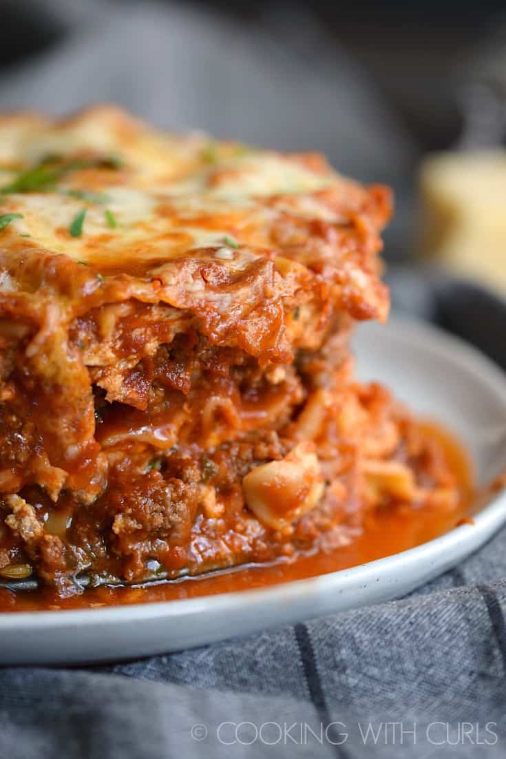 A close up image of Lasagna on a white plate.