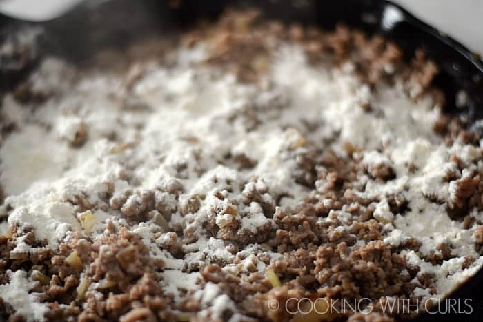 Add flour to the lamb in the skillet © COOKING WITH CURLS