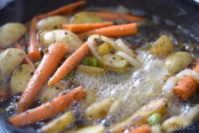 Beer simmering with vegetables in the cast iron skillet.