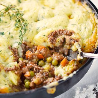 Classic Shepherd's Pie in a cast iron skillet with a scoop out of the lower right corner.