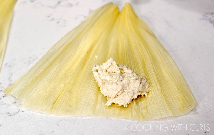 A 1-4 cup of masa in the center of a corn husk © COOKING WITH CURLS
