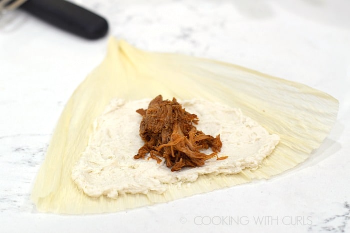 Add red chile pork on top of the masa © COOKING WITH CURLS