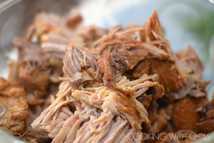 Shred the Red Chile Pork in a large bowl © COOKING WITH CURLS