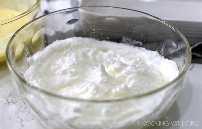 Egg whites beaten to form stiff peaks in a large bowl.