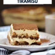 A slice of layered tiramisu on a plate with a pan of tiramisu in the background and title graphic across the top.
