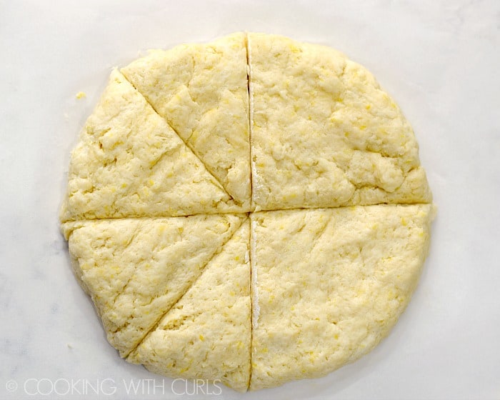 Scones dough shaped into a circle and cut into 8 wedges.