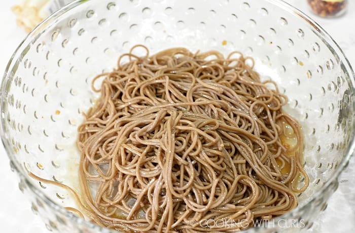 Mix the cooked noodles with the remaining dressing in a large bowl © COOKING WITH CURLS