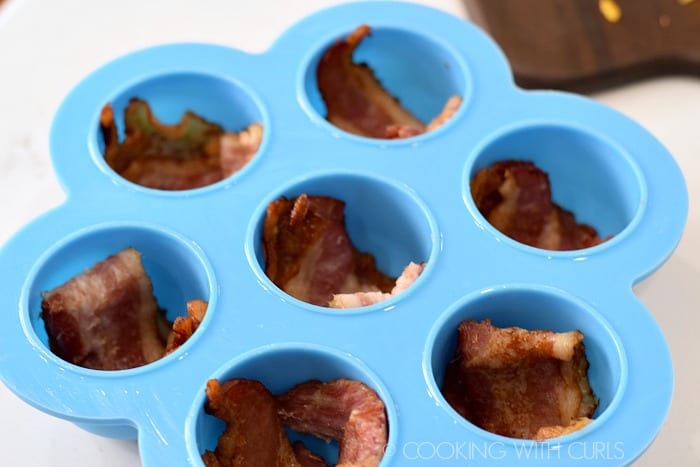 Place bacon in each section of an egg bite mold © COOKING WITH CURLS