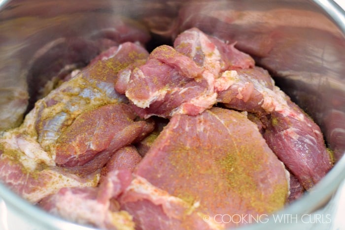 Place the seasoned chunks of pork into the pressure cooker © COOKING WITH CURLS