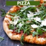 Pizza topped with prosciutto, arugula, shaved parmesan cheese, and tomato sauce with title graphic across the top.