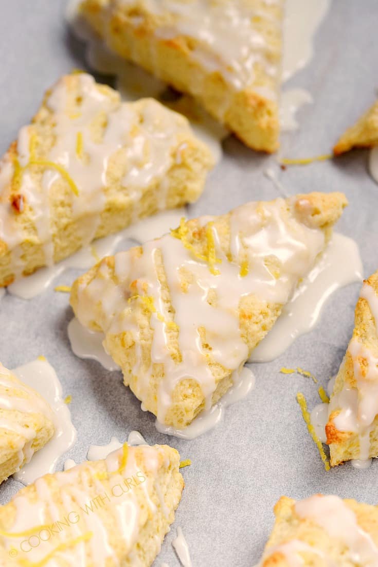 These light and flaky Glazed Lemon Scones are bursting with lemony flavor and topped with a sweet sugar glaze for the perfect morning treat! © COOKING WITH CURLS