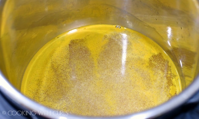 Chicken stock, turmeric, and rice in the pressure cooker liner © COOKING WITH CURLS