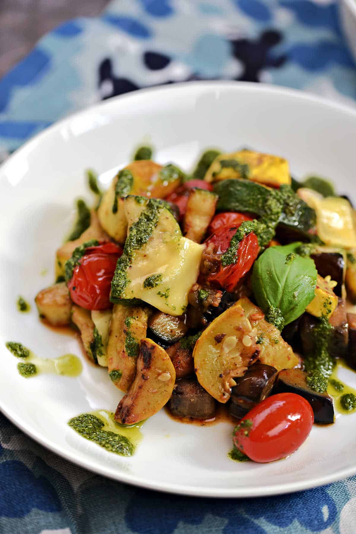 Charred summer vegetables with basil pistou and shaved cheese.