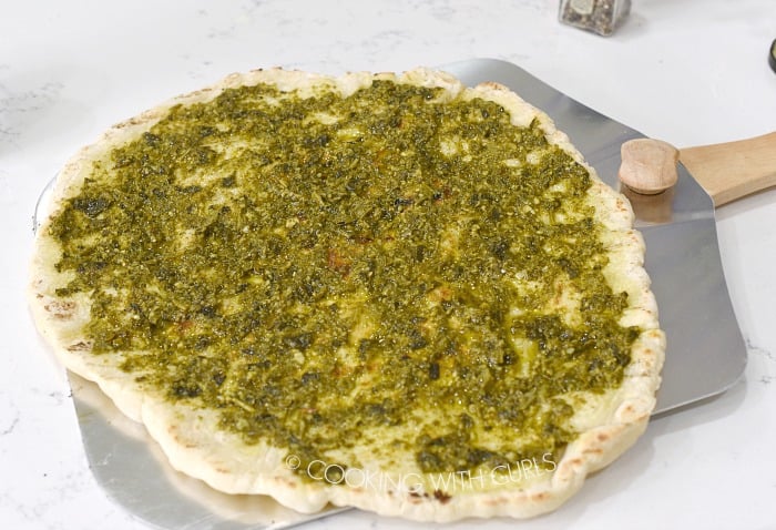 Spread pesto over the grilled pizza crust © COOKING WITH CURLS