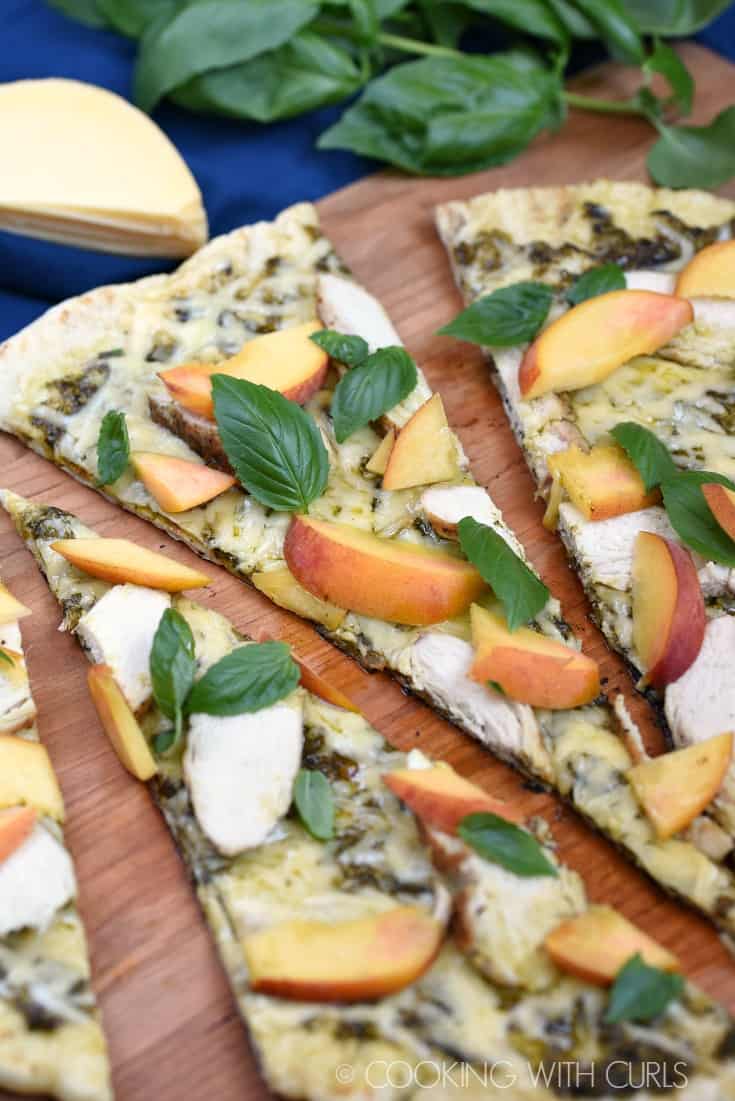 Sweet peaches, salty Gruyere, and a grilled crust combine to make an amazing Grilled Chicken and Peach Pesto Pizza that everyone will love! © COOKING WITH CURLS