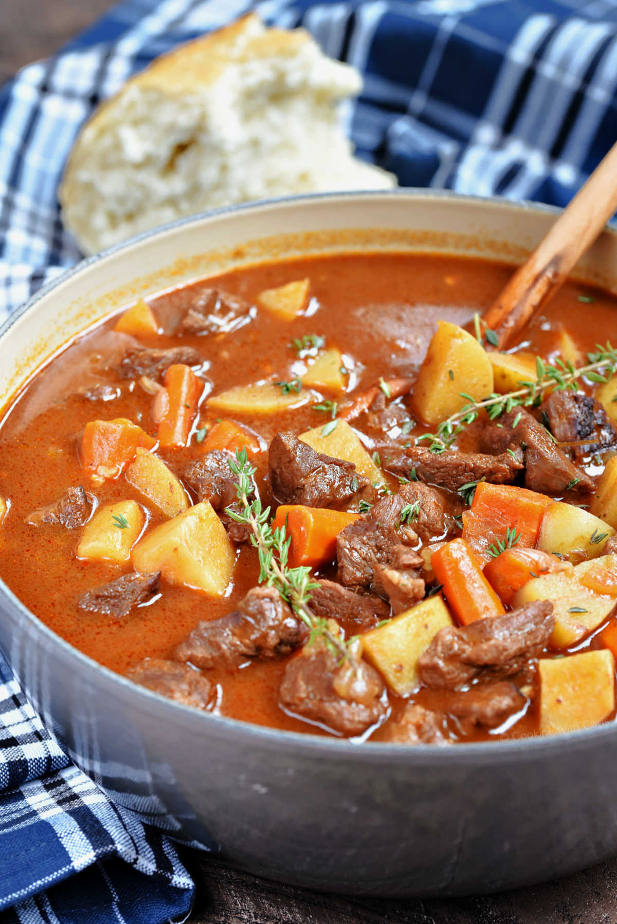 A pot of beef stew with potatoes and carrots in rich gravy.