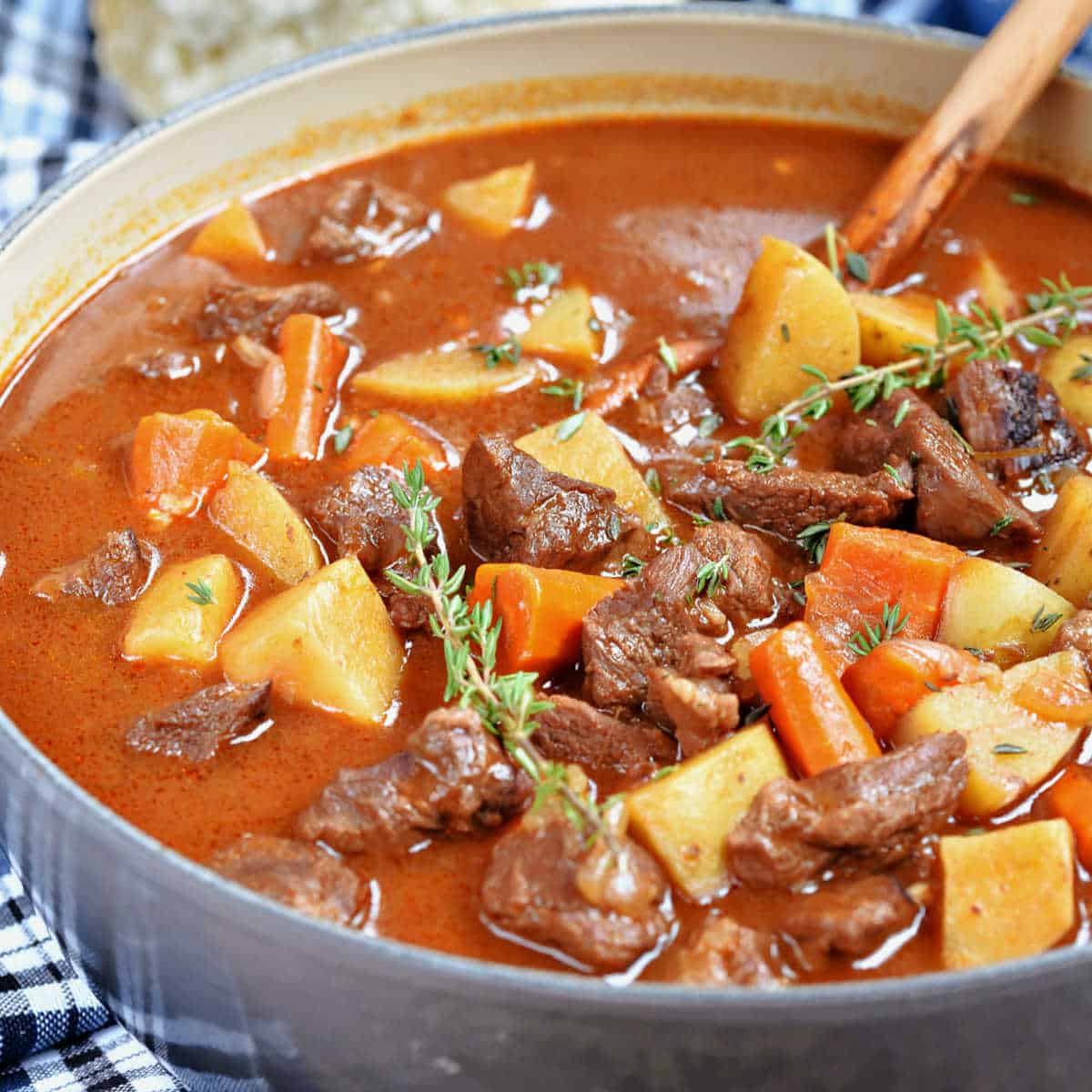 A pot of beef stew with potatoes and carrots in rich gravy.