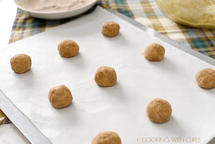Roll cookie dough balls in cinnamon sugar and place on a parchment lined baking sheet cookingwithcurls.com