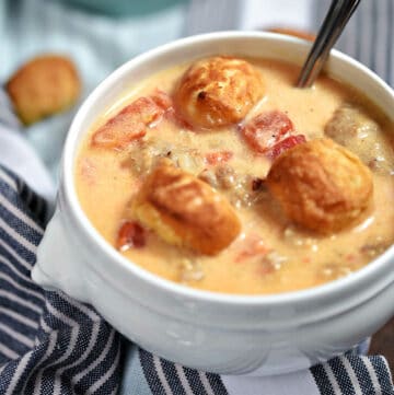 Brats and Beer Cheese Chowder topped with pretzel bites in a soup bowl.